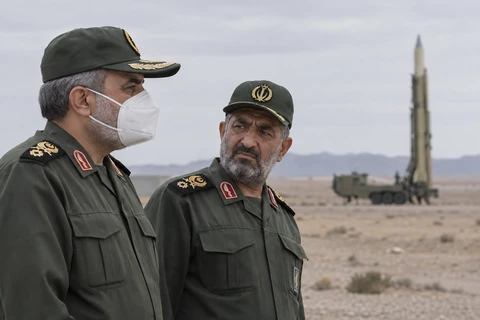 A masked military observer looks toward a missile at an outdoor launch site.